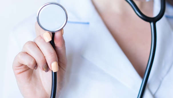 a woman in a white shirt holding a stethoscope